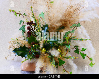 Christmas arrangement holly, ivy and pampas grass in a shoe front view Stock Photo