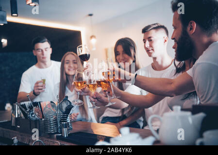 Leisure and communication concept. Group of happy smiling friends enjoying drinks and talking at bar or pub