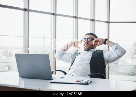 Worker is a young man with a laptop in the office Stock Photo