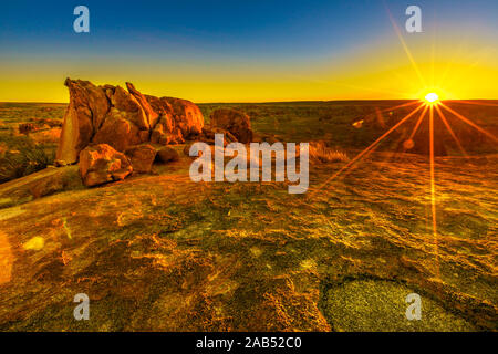 Sunbeams light and sunset colors sky over giant granite boulders at Karlu Karlu or Devils Marbles in Northern Territory, Australia. Nyanjiki Lookout