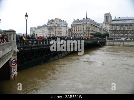 Paris/ France: 03 june 2016. People on the Arcole bridge watching the flood of the river Seine. Stock Photo