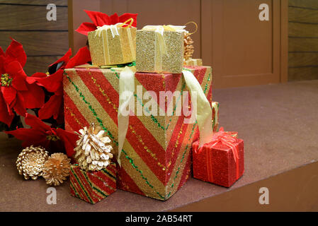 Christmas decorations with Stack of big and small gift boxes and dry pine cones on the floor Stock Photo
