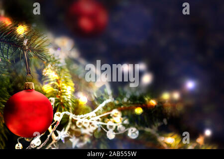 Shiny glimmering Christmas decorations and ornaments. Blurred Christmas lights in the background. Stock Photo