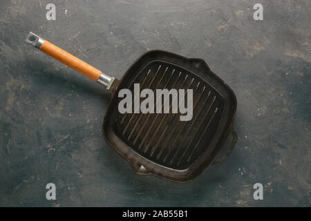 cast iron frying pan, dark wooden,  kitchen, concrete table, kitchen table, cast iron grill Stock Photo