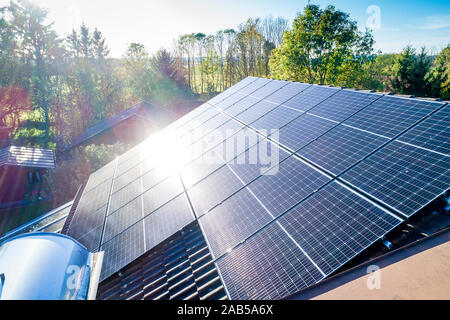 Solar panels and sunlight reflextions on the roof against blue sky background. Concept clean power energy. Stock Photo