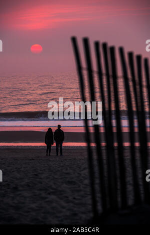 Couple standing on the beach in sunset Stock Photo