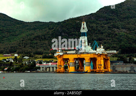 Large offshore oil rig drilling platform in Norway behind the mountains Stock Photo