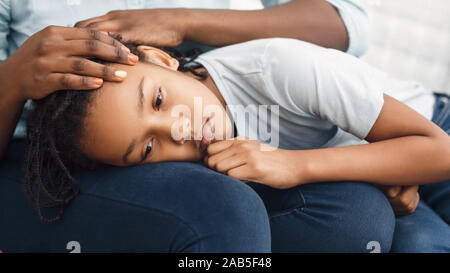 Close-up of black girl's head laying on lap Stock Photo
