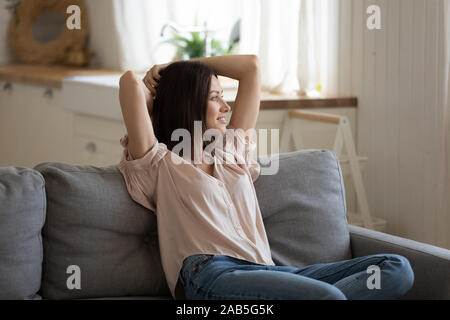 Relaxed lazy lady holding hands behind head lounge on sofa Stock Photo