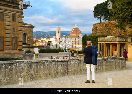 Tourist gentleman taking photos of the historic centre of Florence, Unesco World Heritage Site, from Boboli Gardens of Palazzo Pitti, Tuscany, Italy Stock Photo