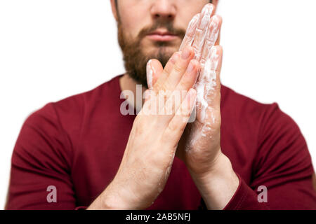 Health beauty and skin care concept. Closeup young bearded man with beard soap or shampoo on his hand for washing beard, cleaning concept Stock Photo