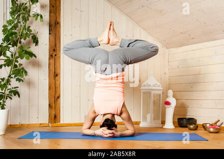 Eine junge Frau, die in schoener Umgebung Yoga-Uebungen durchfuehrt Stock Photo