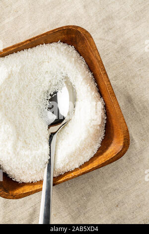 Grated coconut in wooden bowl . Top view. Stock Photo