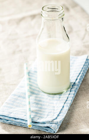 Milk in glass bottle on checkered napkin.