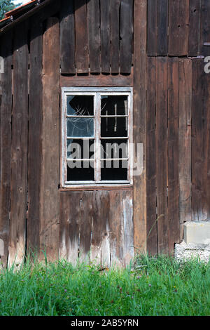 Broken window in an abandoned weathered shed Stock Photo