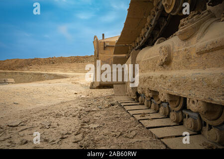 excavator summarizes soil on construction site in dry summer season Stock Photo