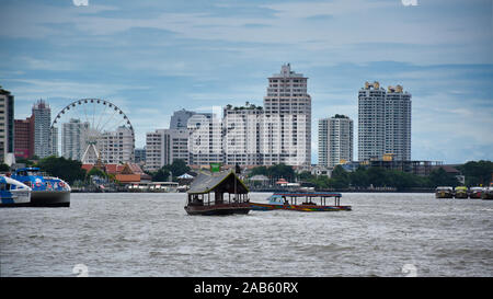 Bangkok, Thailand .11.24.2019: Cityscape view of Bangkok with boats on the Chao Phraya River and with the Asiatique Sky Ferris wheel of the Asiatique Stock Photo