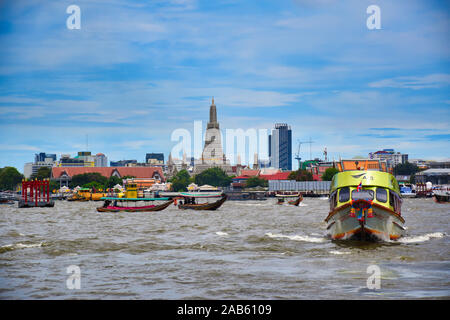 Bangkok, Thailand .11.24.2019: Cityscape view of Bangkok with motor boats, long tailed boats, traditional wooden boats on the Chao Phraya River with t