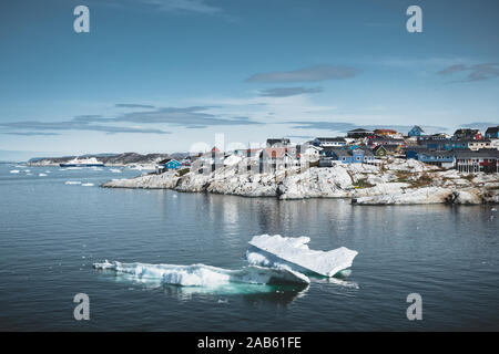 Aerial View of Arctic city of Ilulissat, Greenland. Colorful houses in the center of the town with icebergs in the background in summer on a sunny day Stock Photo