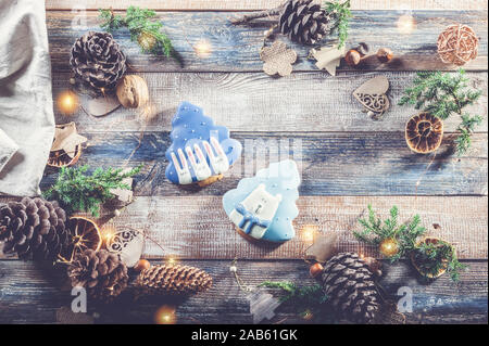 Christmas pattern with gingerbread, juniper twigs, toys and decorations made of natural materials on a rustic table. Top view Stock Photo