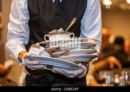 Chicago, Illinois - A waiter clears dishes away after a banquet at the Holiday Inn O'Hare. Stock Photo