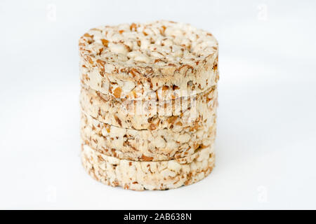 Round crunchy crispbreads on a white background. Round shaped cereal bread, healthy food without yeast. puffed multigrain crispbreads for diet. Stock Photo