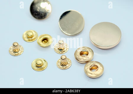 Metal button for clothes, gold color. Sewing accessories for outerwear production. Components of the press-stud with a flat top on a white background Stock Photo