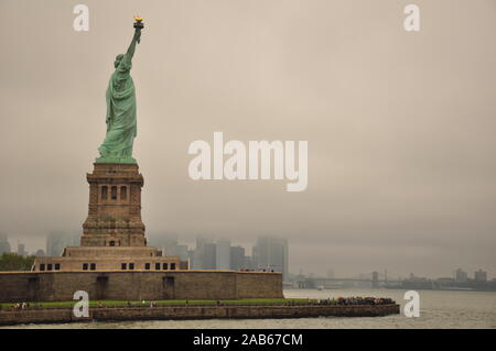 Statue of Liberty and Manhattan on a cloudy day Stock Photo