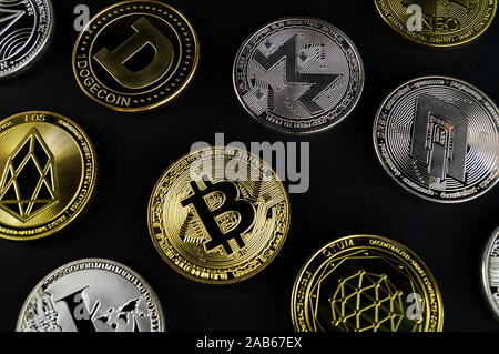 A lot of cryptocurrency coins lie on a dark surface background Stock Photo