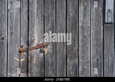 Close up of a utility shed door with a rusty padlock and weathered planks Stock Photo
