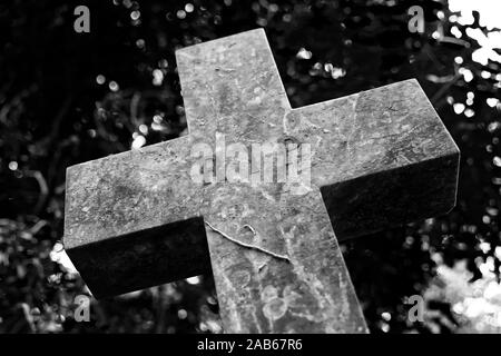 A wonky stone cross in a cemetery with R.I.P sign engraved Stock Photo