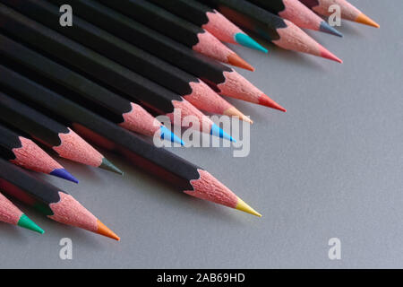 Close-up of an row of black colored pencils against a grey metallic background with copy space. Stock Photo