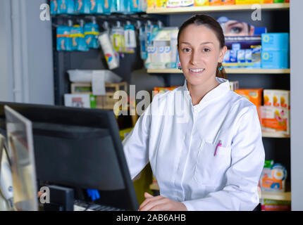 Young female pharmacist working on computer Stock Photo