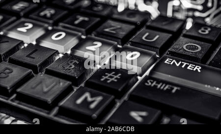 Close up view of keyboard with red light on 2020 number keys and enter key. Technical concept for entrance or start to new year. Happy new year, 2020. Stock Photo