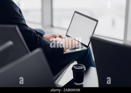 Close up of young freelance business man hands typing on a laptop keyboard while working remotely. Stock Photo