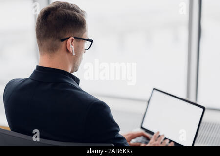 Businessman using laptop with blank screen at public place Stock Photo