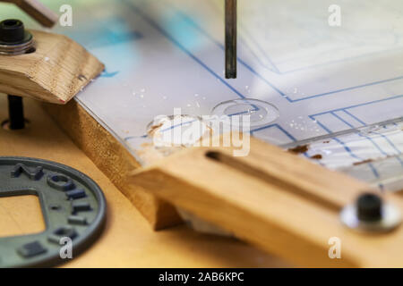 A desktop cnc machine with end mill, cutting out circular shapes from an acrylic sheet. Stock Photo