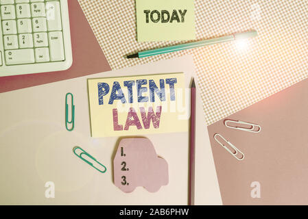 Writing note showing Patent Law. Business concept for deals with an inventor s is exclusive right to use own invention Writing equipments and computer Stock Photo