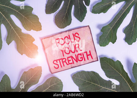 Writing note showing Focus Your Strength. Business concept for Improve skills work on weakness points think more Leaves surrounding notepaper above em Stock Photo
