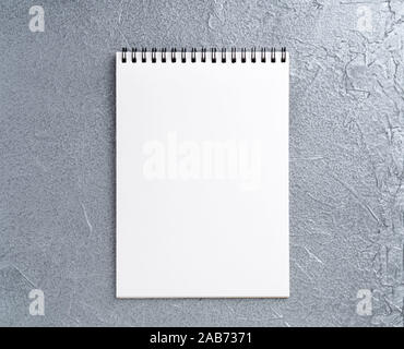 blank sheet of notebook with a spiral on a neutral gray textured silver metallic background Stock Photo
