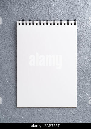 blank sheet of notebook with a spiral on a neutral gray textured silver metallic background Stock Photo