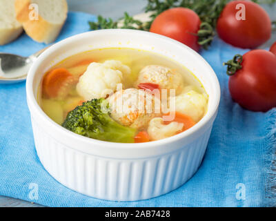 Delicious, thick Soup with Turkey meatballs and mixed vegetables - cauliflower, broccoli, carrots, potatoes, garlic, tomatoes.  Close-up, side view Stock Photo