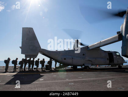 191124-N-IQ884-1071  PACIFIC OCEAN (November 24, 2019) Marines attached to the 11th Marine Expeditionary Unit (MEU) load into the back of a MV-22 Osprey attached to Marine Medium Tiltrotor Squadron (VMM) 163 on the flight deck of amphibious assault ship USS Boxer (LHD 4). Sailors and Marines 11th Marine Expeditionary Unit (MEU) are embarked on USS Boxer (LHD 4) on a regularly-scheduled deployment.  (U.S. Navy photo by Mass Communication Specialist 2nd Class Dale M. Hopkins) Stock Photo