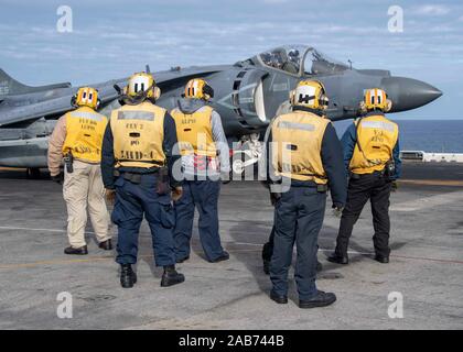 191123-N-KG461-1014  PACIFIC OCEAN (November 23, 2019) Sailors assigned to the amphibious assault ship USS Boxer (LHD 4) standby before an AV-8B Harrier II attached to Marine Medium Tiltrotor Squadron (VMM) 163 (REIN) takes off from the flight deck. Sailors and Marines of the Boxer Amphibious Ready Group (ARG) and 11th Marine Expeditionary Unit (MEU) are embarked on USS Boxer (LHD 4) on a regularly-scheduled deployment.  (U.S. Navy photo by Mass Communication Specialist 3rd Class Zachary D. Behrend) Stock Photo