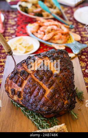 Modern Australian Christmas dinner table with glazed ham, prawns, roast chicken and salads. Stock Photo