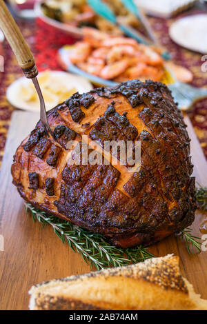 Modern Australian Christmas dinner table with glazed ham, prawns, roast chicken and salads. Stock Photo