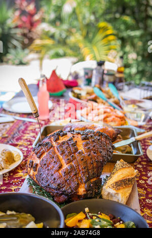 Modern Australian Christmas dinner table with glazed ham, prawns, roast chicken and salads. Stock Photo