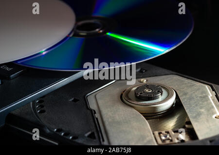 CD on the computer notebook cd rom in darkness. Concept of technological advances in computer data recording systems. Stock Photo