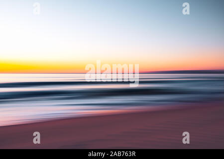 Abstract seascape. Sunrise over the sea. Motion blur, play of ripples.  Pink, yellow, purple, and  blue colors Stock Photo