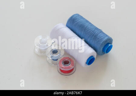 Colored bobbins and spools of thread for machine sewing on a light background close-up Stock Photo
